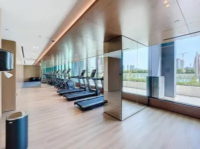 a gym with a row of treadmills in a building at Binghatti Onyx - Two Bedroom with Private Pool in Dubai