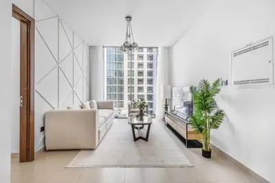 a living room with a couch and a table at New 2BR with BBQ Area, Pool in Sobha MBR City in Dubai