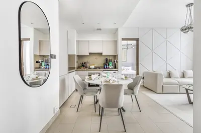 a kitchen and a dining room with a table and chairs at New 2BR with BBQ Area, Pool in Sobha MBR City in Dubai