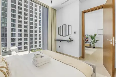 a bedroom with a white bed and a large window at New 2BR with BBQ Area, Pool in Sobha MBR City in Dubai