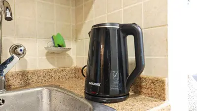 a black kettle sitting on a counter next to a sink at Elegant Studio Near Burj Khalifa Pool and Gym in Dubai