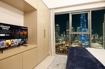 a bedroom with a large window with a view of the city at Burj & Fountain View 5-Min Walk to Dubai Mall in Dubai