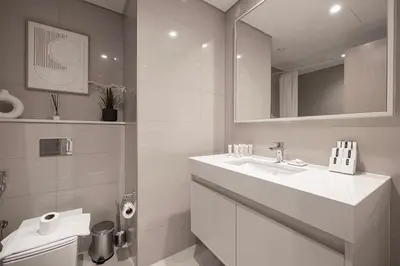 a white bathroom with a sink and a toilet at Burj & Fountain View 5-Min Walk to Dubai Mall in Dubai