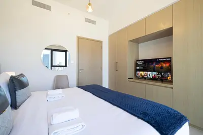 a bedroom with a large bed with a flat screen tv at Burj & Fountain View 5-Min Walk to Dubai Mall in Dubai