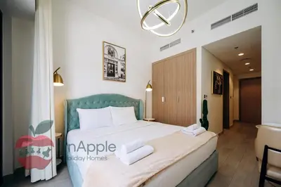a bedroom with a large bed with two towels at Stylish studio in Azizi 42 in Dubai