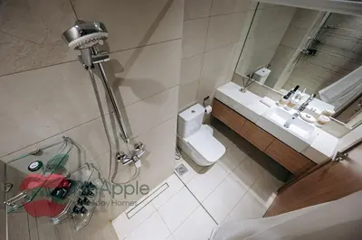 a bathroom with a toilet and a sink and a mirror at Stylish studio in Azizi 42 in Dubai