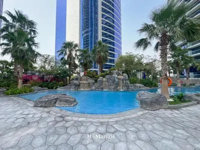 a pool in the middle of a city with palm trees at Luxury 1BR Apartment in Paramount Top-Floor Retreat in Dubai