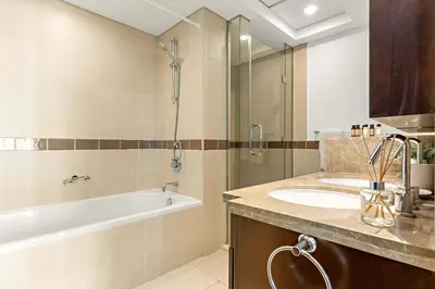 a bathroom with a tub and a sink and a shower at Silkhaus Elite 1BDR at 29 Boulevard Downtown in Dubai