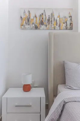 a bedroom with a bed and a nightstand with a lamp at Beautiful view, fully-equipped apartment in Dubai