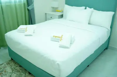 a large white bed with white pillows and certificates on it at Zapbed House-Cozy 2 BR Apartment In The Greens Golf View in Dubai