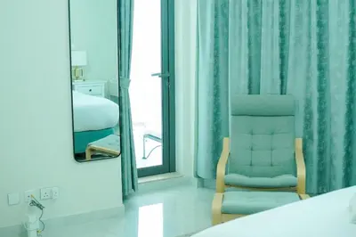 a room with a bed and a chair and a mirror at Zapbed House-Cozy 2 BR Apartment In The Greens Golf View in Dubai