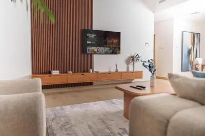 a living room with a flat screen tv on a wall at High-End Luxury 1BR in Port De La Mer near J1 Beachfront, Dubai in Dubai