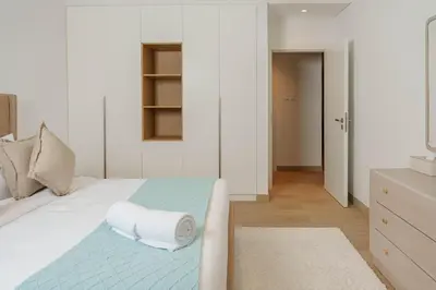 a bedroom with a bed with towels on it at High-End Luxury 1BR in Port De La Mer near J1 Beachfront, Dubai in Dubai
