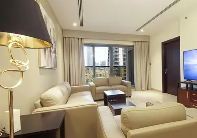 a living room with white furniture and a tv at Luxury 3BR Apartment By Elite Residence Downtown in Dubai