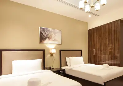 a hotel room with two beds and a chandelier at Luxury 3BR Apartment By Elite Residence Downtown in Dubai