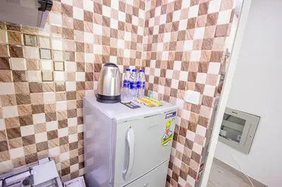 a small refrigerator with a coffee maker on top of it at Cozy Studio for Daily Rental Warsan in Dubai