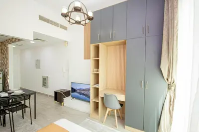 a living room with a dining area and a room with a table at Cozy Studio for Daily Rental Warsan in Dubai