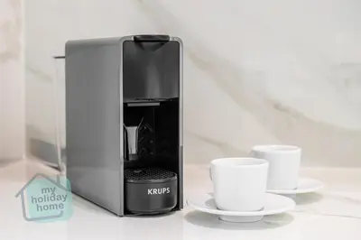 a coffee maker and two cups on a counter at Fully furnished with stunning panoramic view in Dubai