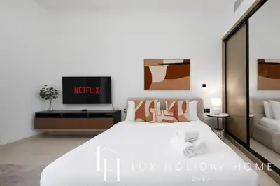 a bedroom with a large white bed and a couch at LUX The Modern Binghatti Canal Suite 2 in Dubai