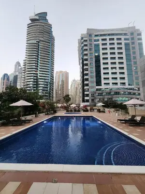 a large swimming pool in a city with tall buildings at Marina Nest - Spacious one bed apt with a view in Marina, walking distance from JBR, metro & tram! in Dubai