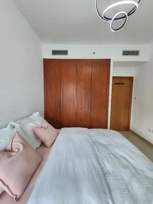 a bedroom with a large bed with a wooden cabinet at Marina Nest - Spacious one bed apt with a view in Marina, walking distance from JBR, metro & tram! in Dubai