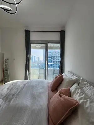 a bedroom with a bed with pillows and a window at Marina Nest - Spacious one bed apt with a view in Marina, walking distance from JBR, metro & tram! in Dubai