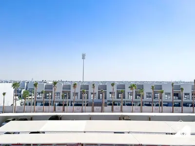 a view of a building with palm trees in the background at Mag City 920 Modern Studio Minutes from Downtown in Dubai