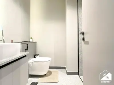 a white bathroom with a toilet and a sink at Mag City 920 Modern Studio Minutes from Downtown in Dubai
