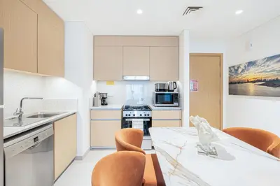 a kitchen with a table and chairs and a counter top at Chic Bright Home in Creek Beach with Lagoon Access in Dubai