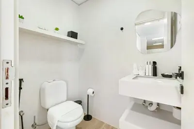 a white bathroom with a toilet and a sink at Waves- Cozy 1BR Lakefront Stay in JLT in Dubai