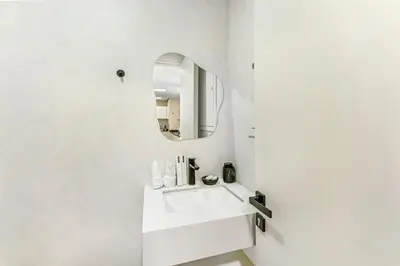 a white bathroom with a sink and a mirror at Waves- Cozy 1BR Lakefront Stay in JLT in Dubai