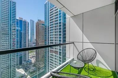 a balcony with two tables and chairs on a city at Waves- Cozy 1BR Lakefront Stay in JLT in Dubai