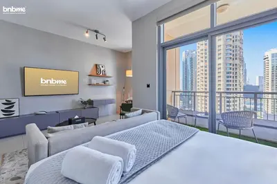 a bedroom with a bed and a large window at bnbmehomes - Claren Tower in Dubai