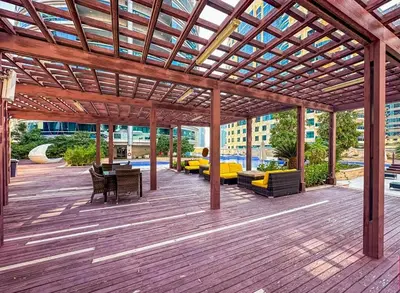 a wooden deck with a pergola with tables and chairs at Female - Girls Joyful Journeys - girls only bedspace in Dubai