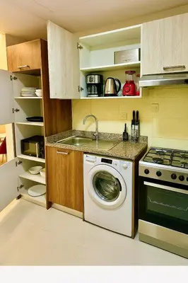 a kitchen with a washing machine and a sink at Comfy Studio in JVC Great Location Fast Wi-Fi in Dubai
