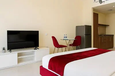 a bedroom with a bed and a flat screen tv at Comfy Studio in JVC Great Location Fast Wi-Fi in Dubai