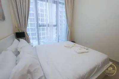 a white bed in a room with a window at Luxury 2-BHK Apartment Located in Azizi riviera 47 Riv 47-419 in Dubai