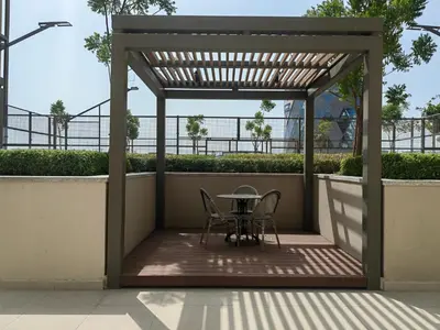 a pergola with a table and chairs on a patio at Cozy 1 bdr apartment with pool and beach access in Dubai