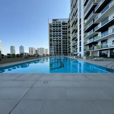 a large swimming pool in the middle of a building at Luxurious Belvilla 1BR JVC with Pool, Gym & BBQ Access in Dubai