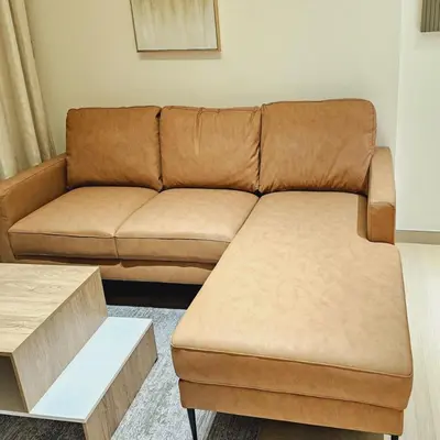 a brown couch sitting in a living room at Luxurious Belvilla 1BR JVC with Pool, Gym & BBQ Access in Dubai