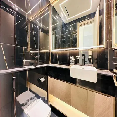 a bathroom with a toilet and two sinks and a mirror at Luxurious Belvilla 1BR JVC with Pool, Gym & BBQ Access in Dubai