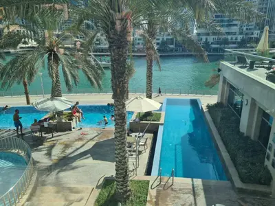 an aerial view of a swimming pool with palm trees at Elegant 1BR At Sanibel Tower park Island Tower Dubai Marina by al sarya holiday homes in Dubai