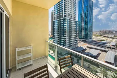 a balcony with a view of a city with tall buildings at Chill Studio with Balcony and Pool View in Dubai