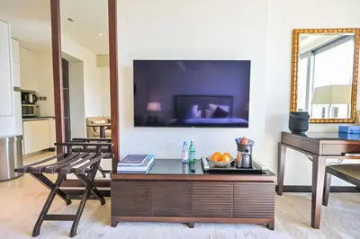 a living room with a table and a tv at Studio on the 30th Floor with Stunning Marina View in Dubai