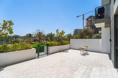 a patio with a table and chairs on a building at Escape24 Elegant 2BR with Garden View in Dubai Hills in Dubai