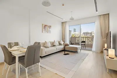 a living room with a white couch and a table at FIRST CLASS 1BR Spacious Comfort Awaits in Dubai