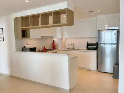 a kitchen with white cabinets and a stainless steel refrigerator at DVR 4 BR Apartment available in Downtown View 2 in Dubai