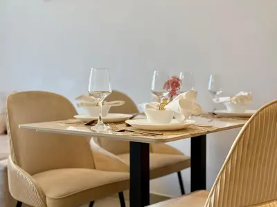 a dining room table with chairs and a table with wine glasses at Brand New - Fully Furnished Premium 1BR in JVC in Dubai