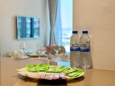 two bottles of water and a plate of food on a table at Brand New - Fully Furnished Premium 1BR in JVC in Dubai