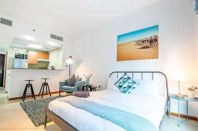 a bedroom with a bed and a living room at Cozy Chic Studio l Next to Marina Mall in Dubai